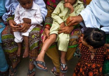 In this image taken on May 8, 2019, Pakistani women hold their HIV infected children as they gather at a house at Wasayo village in Rato Dero in the district of Larkana of the southern Sindh province. - Parents nervously watch over their children as they jostle in line to …