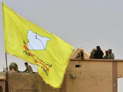 Fighters of the Syrian Democratic Forces (SDF) stand atop a roof next to their unfurled flag at a position in the village of Baghouz in Syria's eastern Deir Ezzor province near the Iraqi border on March 24, 2019, a day after the Islamic State (IS) group's "caliphate" was declared defeated …