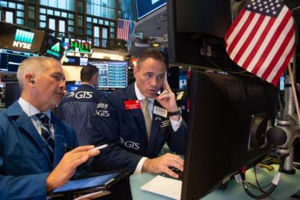 Traders work on the floor at the opening bell of the Dow Industrial Average at the New Yor