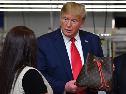 US President Donald Trump holds a bag during a visit to the new Louis Vuitton factory in Alvarado (40 miles south of Fort Worth), Johnson County, Texas on October 17, 2019. - A workshop of the French brand Louis Vuitton will be inaugurated in Texas by Donald Trump, in the …