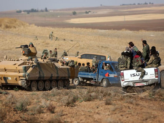 Turkey-backed Syrian fighters and Turkish troops gather at a position east of the northeas