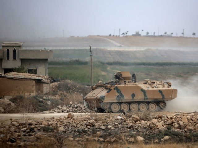 An armoured personnel carrier transports Turkey-backed Syrian fighters on the road between