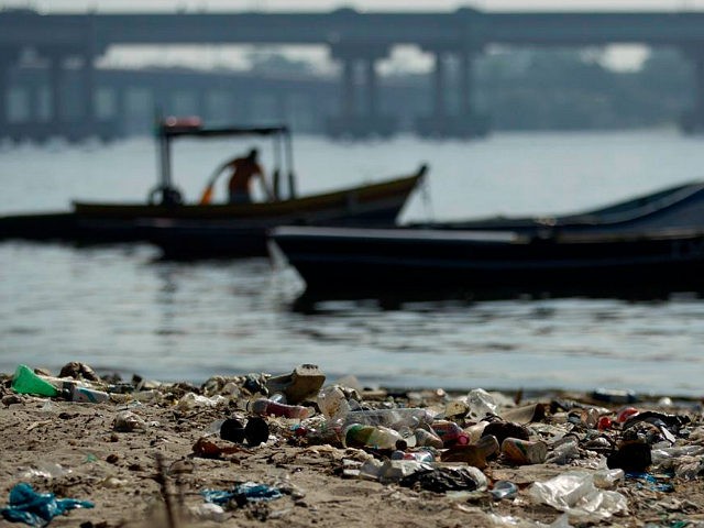 In this photo taken on Friday, June 15, 2012, a fisherman takes his boat onto a trash-ridden beach on Guanabara Bay near the international airport in Rio de Janeiro, Brazil. The throngs streaming into Rio for the United Nations Conference on Sustainable Development or Rio+20 may be dreaming of white-sand …