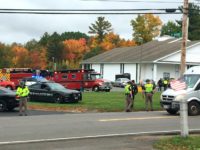 In this photo provided by WMUR-TV, police stand outside the New England Pentecostal Church on Saturday, Oct. 12, 2019, in Pelham, N.H. (Siobhan Lopez/WMUR-TV via AP)