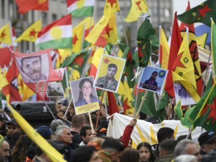 Kurdish protesters wave their national flags and hold photos of Kurdish political leader killed last week Hevrin Kahlaf, during a pro-Kurdish demonstration in Cologne, western Germany on October 19, 2019. (Photo by Ina Fassbender / AFP) (Photo by INA FASSBENDER/AFP via Getty Images)
