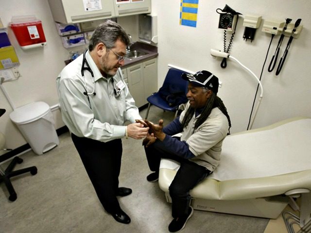 In this photo taken Thursday, Feb. 18, 2016, Doctor Leonid Basovich, left, examines Medi-C