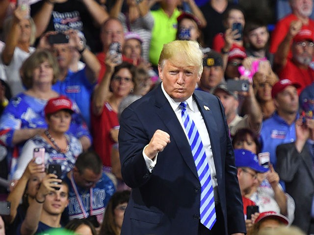 TOPSHOT - US President Donald Trump salutes his supporters after speaking at a political rally at Charleston Civic Center in Charleston, West Virginia on August 21, 2018. - Trump's administration announced a plan on August 21 to weaken regulations on US coal plants, giving a boost to an industry that …