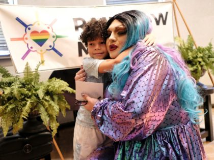 From left, Driston Freeman, 6, hugs drag performer Khloe Kash at the Mobile Public Library during Drag Queen Story Hour in Mobile, Ala. on Saturday, Sept. 8, 2018. The event, sponsored by LGBT group Rainbow Mobile, involves local drag queen performers reading to children. (AP Photo/Dan Anderson)