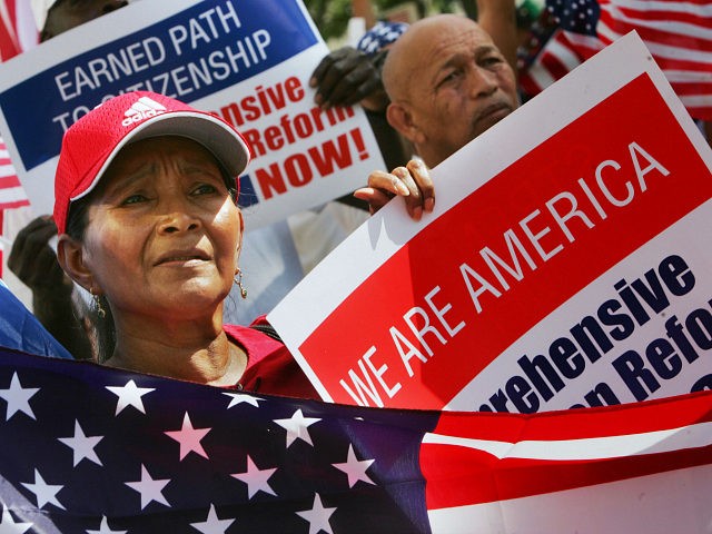 A woman joins hundreds of other immigrants during a rally in downtown Miami 01 May 2007. Tens of thousands of activists rallied across the United States to demand an overhaul of immigration laws and greater rights for the country's estimated 12 million illegal workers. AFP PHOTO/Roberto SCHMIDT (Photo credit should …