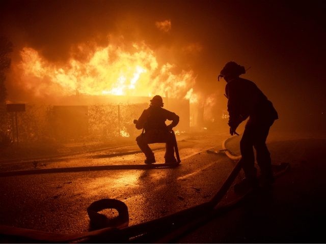 Firefighters try to save a home on Tigertail Road during the Getty fire, Monday, Oct. 28,