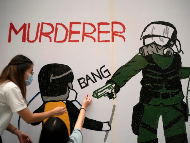 Protestors make a mural depicting a teenage demonstrator shot at close range in the chest