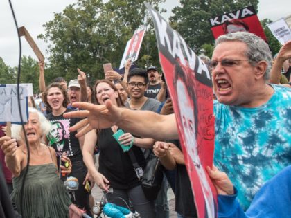 A Trump supporter is heckled by anti-Kavanaugh demonstrators protesting against the appointment of Supreme Court nominee Brett Kavanaugh in Washington DC, on October 6, 2018. - The US Senate confirmed conservative judge Kavanaugh as the next Supreme Court justice on October 6, offering US President Donald Trump a big political …
