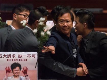 Pro-democracy lawmaker Kwok Ka-ki (C) is escorted by security after throwing flowers insid