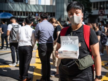 HONG KONG, CHINA - OCTOBER 4: A woman offers masks during a protest against a government ban on face masks in Central on October 4, 2019 in Hong Kong, China. Hong Kong's government invoked emergency powers on Friday to introduce an anti-mask law which bans people from wearing masks at …