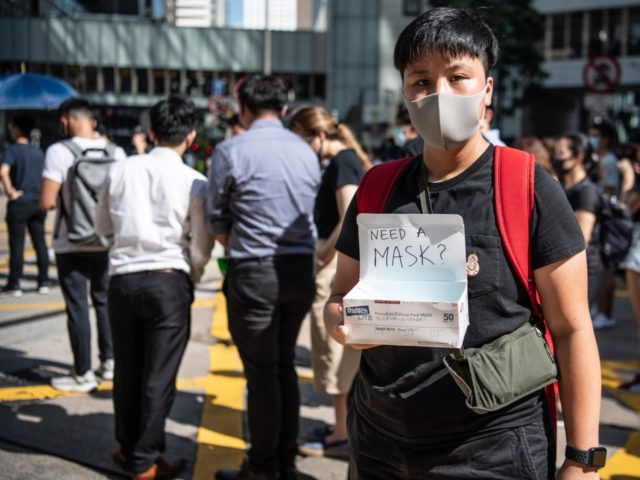 HONG KONG, CHINA - OCTOBER 4: A woman offers masks during a protest against a government b