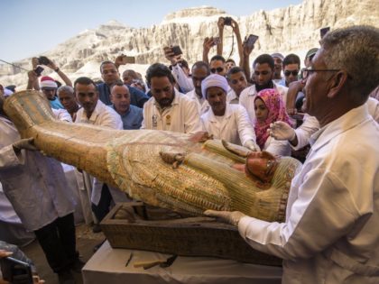 Egyptian archeologists open a wooden sarcophagus belonging to a man in front Hatshepsut Te