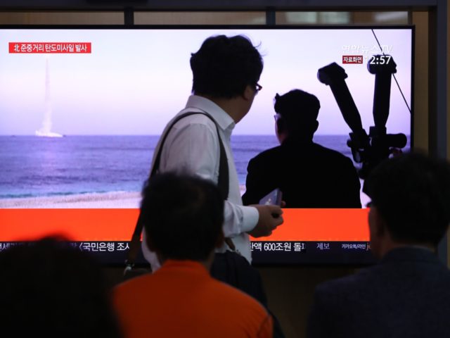 SEOUL, SOUTH KOREA - OCTOBER 02: People watch a TV showing a file image of a North Korean