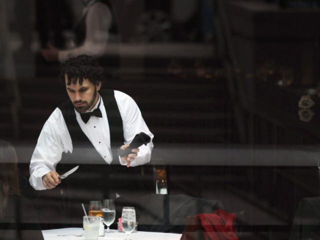 A waiter clears a table at a midtown restaurant popular for business lunches on November 22, 2011 in New York City. As retailers prepare for the start of the traditional holiday shopping season, the Commerce Department revised third-quarter GDP downward to 2 percent from 2.5 percent Tuesday for the quarter …