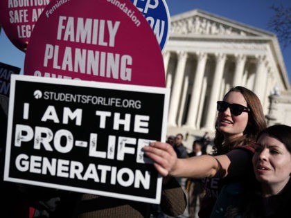 WASHINGTON, DC - JANUARY 19: A pro-life activist tries to block the signs of pro-choice ac