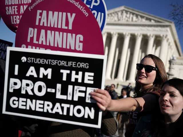 WASHINGTON, DC - JANUARY 19: A pro-life activist tries to block the signs of pro-choice activists in front of the the U.S. Supreme Court during the 2018 March for Life January 19, 2018 in Washington, DC. Activists gathered in the nation's capital for the annual event to mark the anniversary …