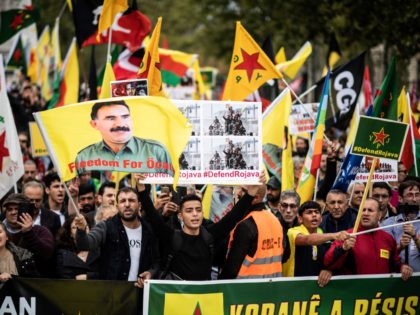 People hold pro-Kurd flags and banner in Paris on October 12, 2019 during a demonstration to support Kurdish militants and protest as Turkey kept up its assault on Kurdish-held border towns in northeastern Syria, on the fourth day of an offensive that is drawing growing international condemnation, even from Washington. …