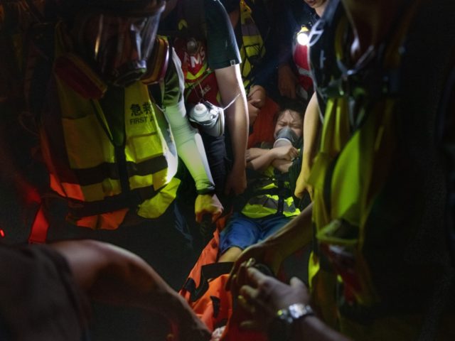 An injured protester is carried away on a stretcher after being shot with a non-lethal rou