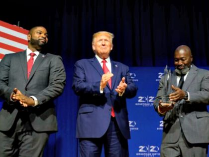 President Donald Trump (C) is awarded the Bipartisan Justice Award by Matthew Charles (R), who was released from federal prison through the First Step Act, prior to delivering remarks at the 2019 Second Step Presidential Justice Forum in Columbia, South Carolina on Oct. 25, 2019. (Jim Watson/AFP via Getty Images) …