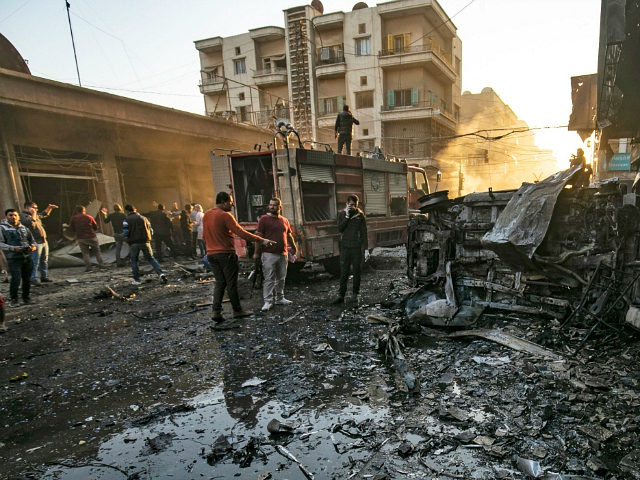Security forces and civilians gather the site of bombings in the Syrian Kurdish-majority city of Qamishli in the northeastern Hasakah province, on November 11, 2019. - Three simultaneous bombings caused by two car bombings and an explosives-rigged motorcycle rocked a market in the Syrian city of Qamishli, killing at least …
