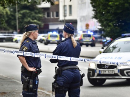 Police stand next to a cordon in central Malmo, southern Sweden, Monday, June 18, 2018. A Swedish newspaper is reporting that four people have injured in a shooting near a police station in the southern city of Malmo. Witnesses told newspaper Aftonbladet they heard what sounded like 15 to 20 …