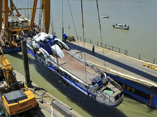 A crane lifts the wreckage of the sightseeing boat out of the Danube river at Margaret Bri