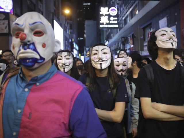 People in Guy Fawkes masks gather on a street in Hong Kong, Thursday, Oct. 31, 2019. Hong