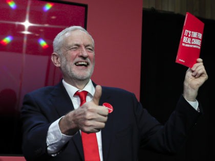 Jeremy Corbyn, Leader of Britain's opposition Labour Party, gives a thumbs up holding a copy of the manifesto on stage at the launch of Labour's General Election manifesto, at Birmingham City University, England, Thursday, Nov. 21, 2019. Britain goes to the polls on Dec. 12. (AP Photo/Kirsty Wigglesworth)