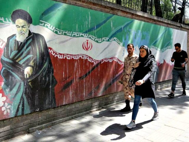 Iranians walk by the former US embassy in Tehran. Atta Kenare/AFP/Getty Images