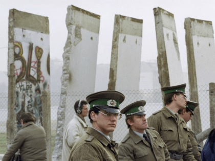 FILE - In this Nov. 13, 1989, file photo, East German border guards stand in front of segments of the Berlin Wall, which were removed to open the wall at Potsdamer Platz passage in Berlin. Months before the Berlin Wall fell on Nov. 9, 1989, with the Soviet stranglehold over …