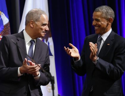 US President Barack Obama (R) applauds to outgoing Attorney General Eric Holder at the por