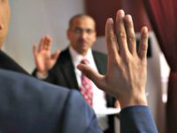 An immigration supervisor swears in new American citizens at a naturalization ceremony ( John Moore/Getty Images )