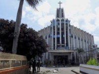 Policemen and soldiers are seen in front of a Catholic Church, where the bombing took place in Jolo, Sulu province on the southern island of Mindanao. - At least 18 people were killed when two bombs hit a church on a southern Philippine island that is a stronghold of Islamist …