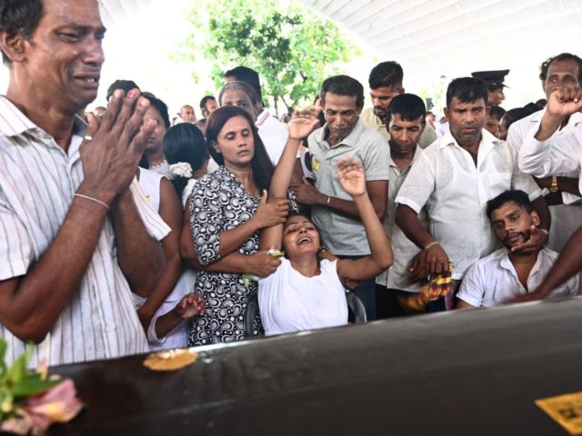 Relatives mourn beside a coffin of a bomb blast victim during a funeral service at St Seba