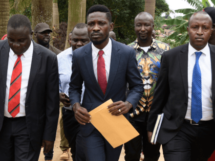Ugandan musician turned politician, Robert Kyagulanyi, commonly known by his stage name Bobi Wine (C), is escorted by Uganda legislators after speaking to the press outside his home, in Kampala, on April 23, 2019. - Ugandan police detained Bobi Wine, on April 22, 2019 a pop star turned MP who …