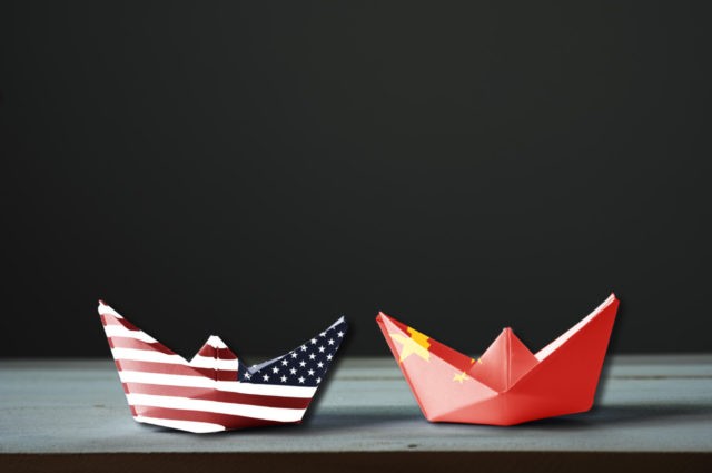 USA flag and China flag print screen on ship with black background.It is symbol of tariff trade war tax barrier between United States of America and China.-Image.