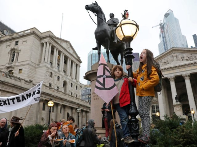 Activists protest outside the Bank of England (L) during the eighth day of demonstrations by the climate change action group Extinction Rebellion, in London, on October 14, 2019. (Photo by ISABEL INFANTES / AFP) (Photo by ISABEL INFANTES/AFP via Getty Images)