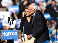 2020 Democratic presidential hopeful US Senator Bernie Sanders (D-VT) and representative Alexandria Ocasio-Cortez (D-NY) hug during a campaign rally on October 19, 2019 in New York City. (Photo by Johannes EISELE / AFP) (Photo by JOHANNES EISELE/AFP via Getty Images)