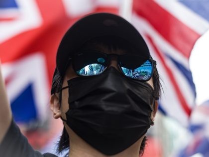 US and British Union Jack flags are seen reflected in a person's glasses as people ta