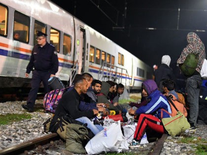 Bosnian police officer patrol outside the train as migrants from Asia and Africa rests after they arrives by train late in the night in Bosanska Otoka, Bosnia, on October 21, 2019. - No running water, putrid portable toilets and surrounding woods littered with land mines these are the bleak conditions …