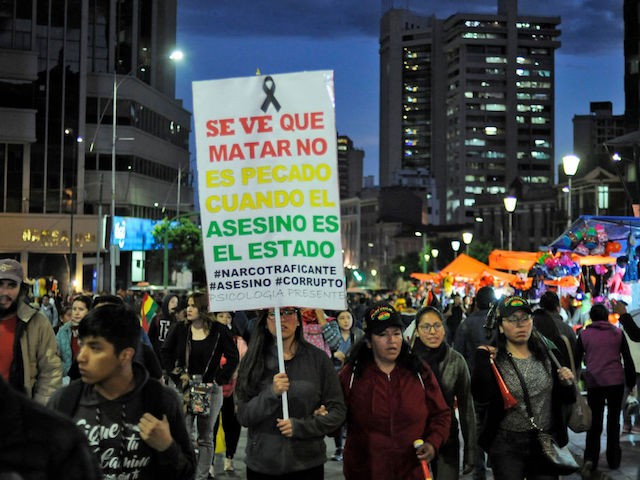 People with a sign reading "It seems like killing is not a sin when the assassin is the state", attend an open forum summoned by the National Committee in Defense of Democracy (CONADE) on the second week of civic strike against the results of the October 20 election in La Paz on October 31, 2019. - A mission of the Organization of American States (OAS) began its audit of the disputed Bolivian presidential election that resulted in a fourth term for President Evo Morales, but sparked deadly riots. (Photo by Jorge Bernal / AFP) (Photo by JORGE BERNAL/AFP via Getty Images)