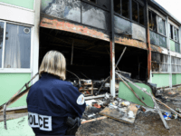 A Police officer stands in front of the burnt facade of the Tamaris elementary school in Beziers, southern France on November 1, 2019, after a fire of criminal origin destroyed several classrooms overnight. (Photo by SYLVAIN THOMAS / AFP) (Photo by SYLVAIN THOMAS/AFP via Getty Images)