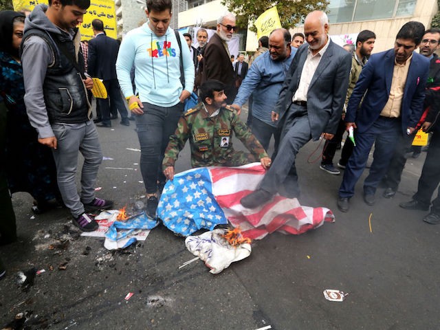Iranian protesters set US flags on fire during a rally outside the former US embassy in the Iranian capital Tehran on November 4, 2019, to mark the 40th anniversary of the Iran hostage crisis. - On November 4, 1979, less than nine months after the toppling of Iran's American-backed shah, students overran the embassy complex to demand the United States hand over the ousted ruler after he was admitted to a US hospital. (Photo by ATTA KENARE / AFP) (Photo by ATTA KENARE/AFP via Getty Images)