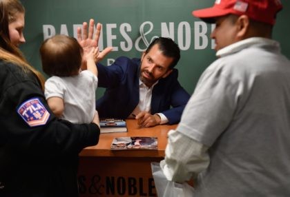 Donald Trump Jr., greets a child as he signs his new Book "Triggered: How the Left Thrives