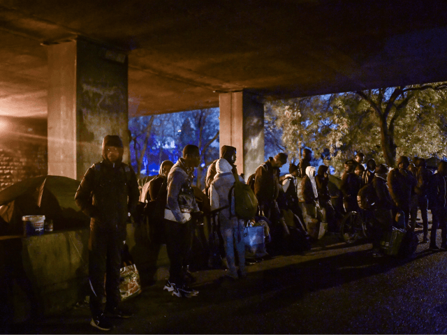 Migrants wait to be evacuated by French police and Gendarmerie in Paris on November 7, 2019. - More than a thousand migrants and homeless have settled camp in this area for months. (Photo by MARTIN BUREAU / AFP) (Photo by MARTIN BUREAU/AFP via Getty Images)