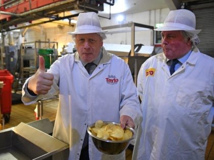 Britain's Prime Minister Boris Johnson (L) gestures besides Tayto Chairman Stephen Hutchinson (R) during a general election campaign visit to the Tayto Castle crisp factory in County Armagh, Northern Ireland, on November 7, 2019. - Britain's two main parties promised billions of pounds of investment for hospitals, schools and infrastructure …